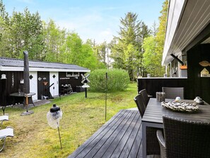 A deck with outdoor furniture, a small shed, and a birdhouse. - 4 Star Holiday Home in Albaek (Aalbaek)