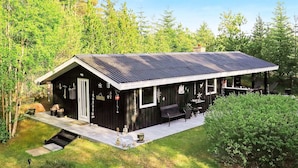 A modern house with a dark exterior, a sloped roof, and a covered patio area. - 4 Star Holiday Home in Albaek (Aalbaek)