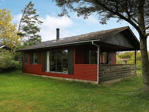 A small, single-story cabin with a sloped roof, large windows, and a porch area. - Seaside Holiday Home with Terrace near Limfjord (Vinderup)