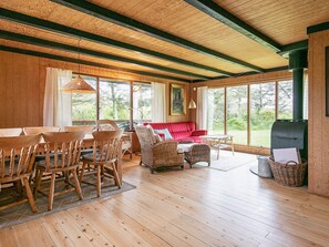 A wooden interior with a dining area, seating, and a fireplace. - Seaside Holiday Home with Terrace near Limfjord (Vinderup)