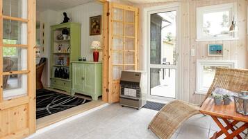 A wooden interior with a dining area, a green cabinet, and a fireplace.