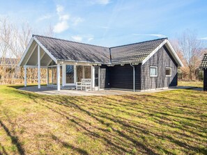 A two-story house with a covered patio, a garage, and a lawn. - Holiday Home in Ebeltoft (Ebeltoft)