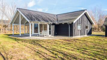 Et moderne hus med en overdækket veranda og garage.