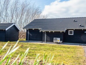 A building with a tiled roof, a small window, and an air conditioning unit on the side. - Holiday Home in Ebeltoft (Ebeltoft)