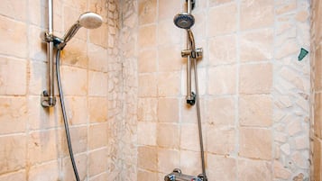 Un espace douche équipé de deux pommes de douche et d’un panneau de commande.
