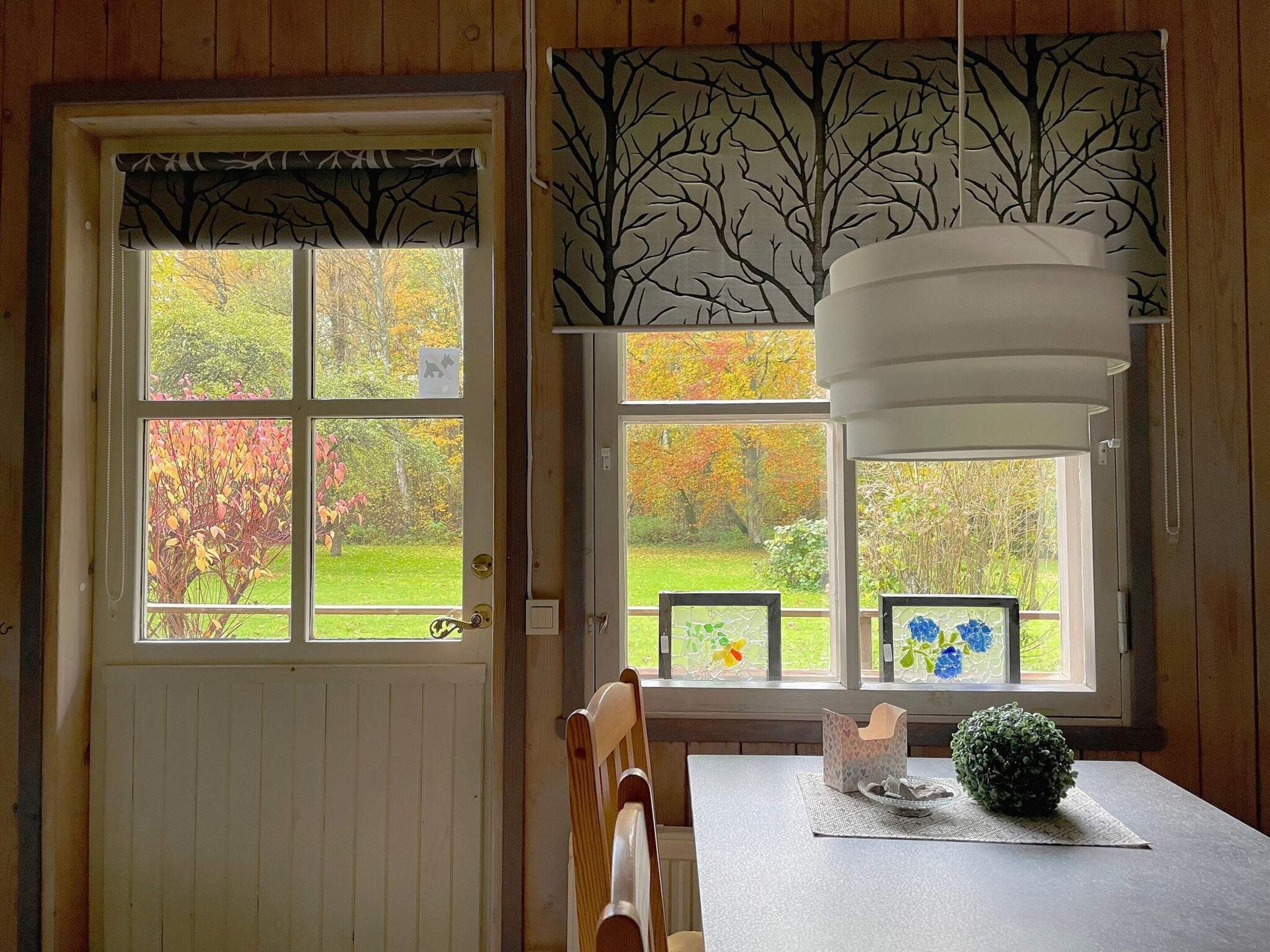 A room with a wooden door, a table with a placemat, a chair, and a hanging light fixture.
