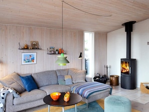 A modern living room with a sectional sofa, a round coffee table, a fireplace, and a wooden ceiling. - 6 Person Holiday Home in Fano (Fano)