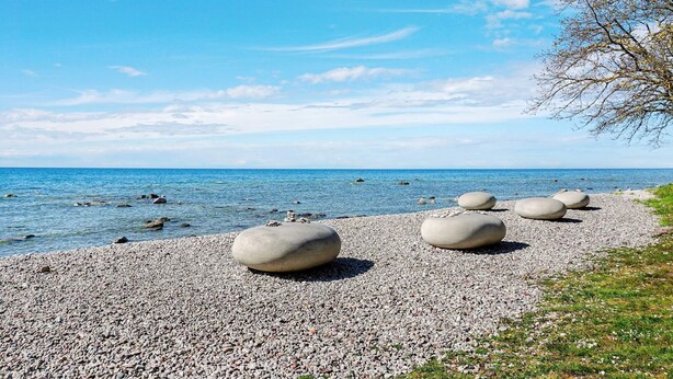 A pebbled beach with large boulders and a clear blue sky. - 6 Person Holiday Home in Visby (Visby)