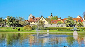 A serene park with a fountain, a duck swimming, and historic buildings in the background. - 6 Person Holiday Home in Visby (Visby)