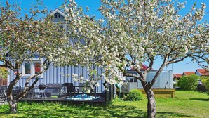 A backyard with a barbecue grill, outdoor seating, and a wooden fence. - 6 Person Holiday Home in Visby (Visby)