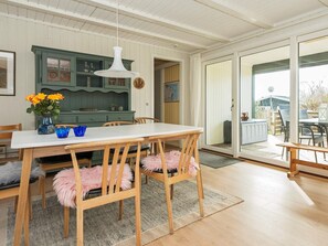 A dining area with a white table, wooden chairs, and a hanging light fixture. - 6 Person Holiday Home in Børkop (Borkop)