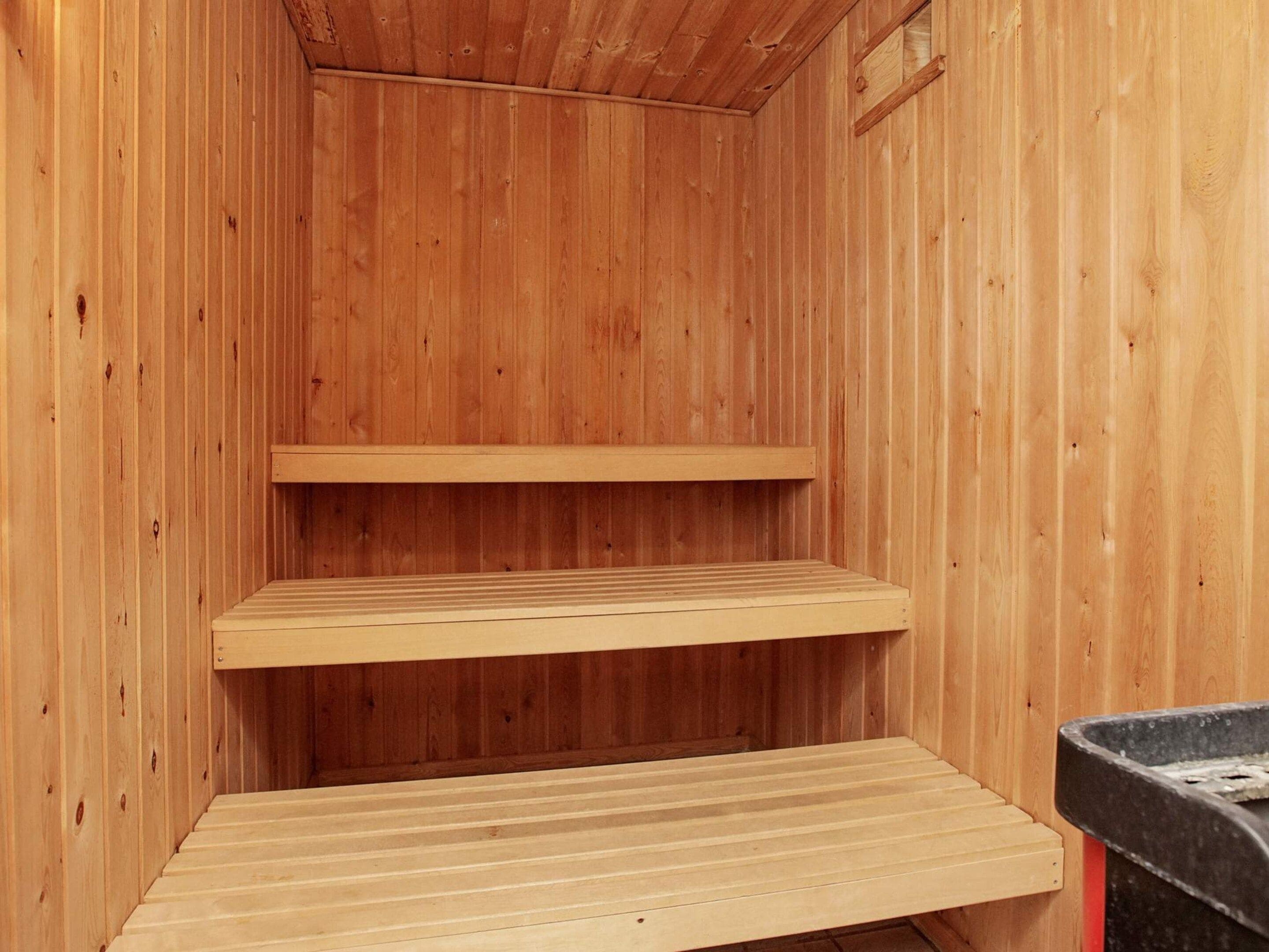 Un intérieur en bois avec trois étagères et un banc.
