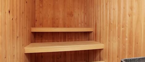 Un intérieur en bois avec trois étagères et un banc.