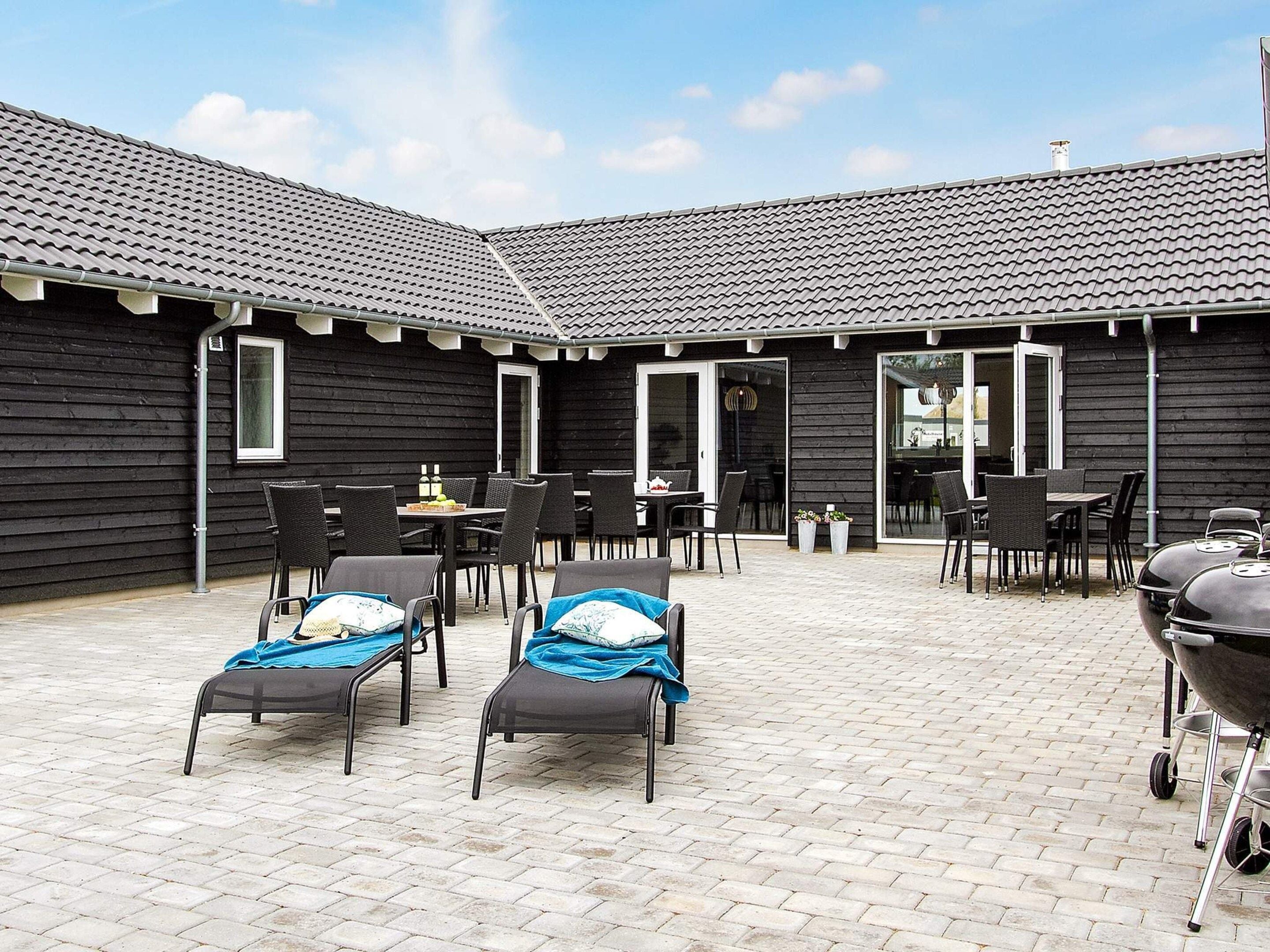 A patio area with outdoor seating and a barbecue grill.