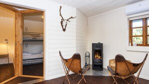 Une pièce chaleureuse avec une cheminée, des meubles en bois et un décor composé d’un crâne de cerf.