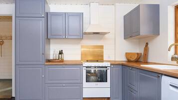 Una cocina moderna con armarios grises, una estufa blanca y una encimera de madera.