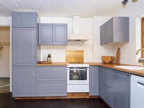 Eine moderne Küche mit grauen Schränken, einem weißen Herd und einer Holz Arbeitsplatte.