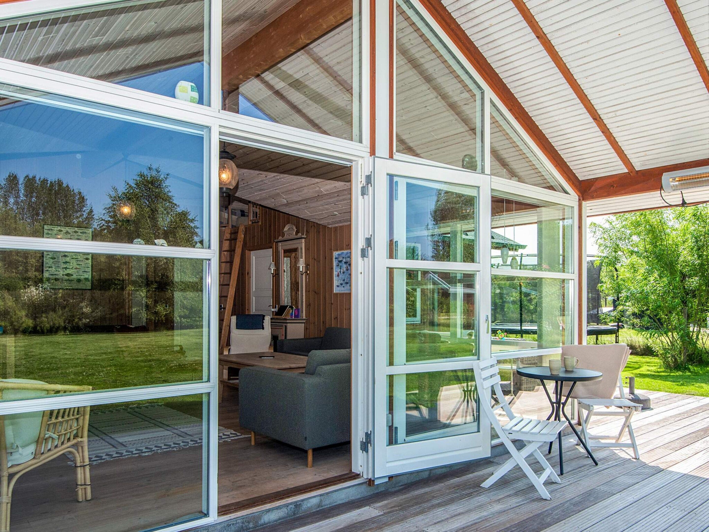 A modern house with large glass doors leading to an outdoor deck.