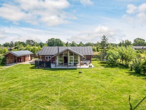 A modern house with a large glass front, a covered porch, and a well-maintained lawn. - Holiday Home in Glesborg (Glesborg)
