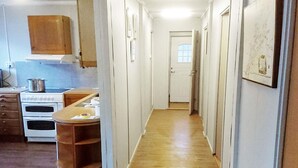 A narrow hallway with wooden flooring, white walls, and a white door at the end. - 8 Person Holiday Home in Revsnes (Åfjord)