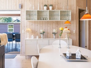 Un interior moderno con comedor, muebles blancos y detalles decorativos.