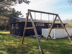 A small wooden cabin with a swing set in front. - 5 Person Holiday Home in Hurup Thy (Hurup Thy)