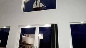 A room with a large window and a smaller window above it, both with white frames. - 4 Star Holiday Home in Stromstad (Stromstad)