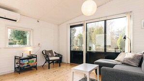A modern living room with a sofa, a chair, a small table, and a bookshelf. - 6 Person Holiday Home in Follenslev (Follenslev)