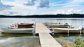 A calm lake with several boats docked at a wooden pier.