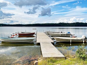 A calm lake with several boats docked at a wooden pier. - 6 Person Holiday Home in Granna (Gränna)