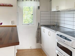 A kitchen with white cabinets, a stainless steel sink, and a built-in oven. - 6 Person Holiday Home in Granna (Gränna)