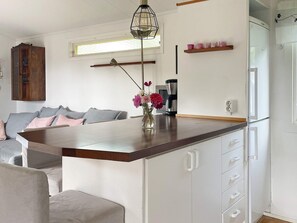 A modern kitchen with a wooden countertop, white cabinets, and a coffee maker. - 6 Person Holiday Home in Granna (Gränna)