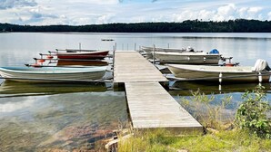Un muelle de madera con varias embarcaciones amarradas al final.