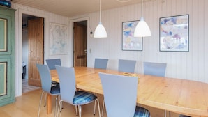 A dining area with a wooden table, six chairs, pendant lights, and two framed abstract paintings on the wall. - 6 Person Holiday Home in Knebel (Knebel)
