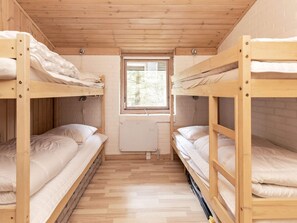 Une chambre avec des lits superposés, une fenêtre et un radiateur.