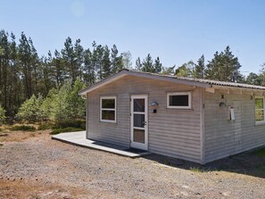 A small, single-story cabin with a front door, two windows, and a small porch area. - 4 Person Holiday Home in Nexo (Nexø)