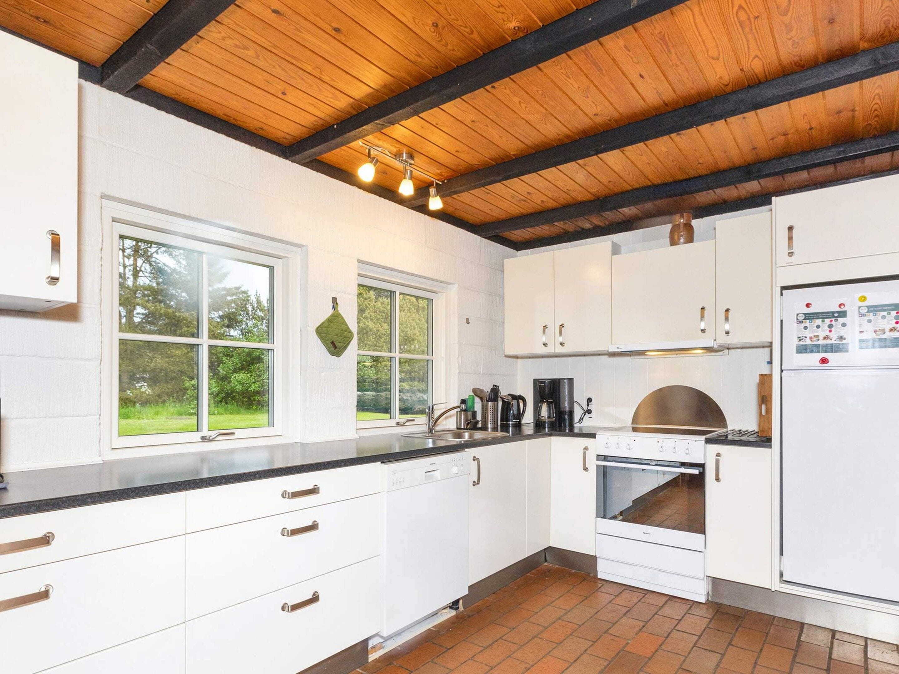A kitchen with white cabinets, a stainless steel sink, and a built-in oven.