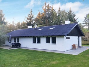 A white building with a dark roof, a satellite dish, and a sign reading 'Dolenharad.' - 6 Person Holiday Home in Bindslev (Bindslev)