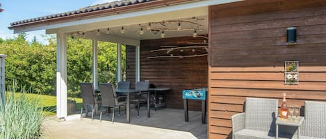 A covered patio area with outdoor seating, a table, and a sign indicating a soccer area.