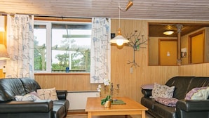 A cozy living room with two leather sofas, a wooden coffee table, and a large window with curtains. - 6 Person Holiday Home in Romo (Rømø)