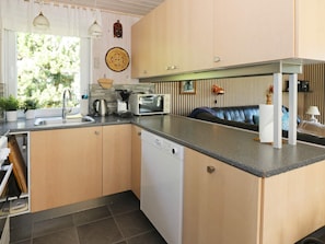 A compact kitchen with a dishwasher, a coffee maker, and a microwave.