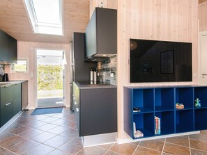 A modern kitchen with a built-in stove, a microwave, and a large window above the sink. - 5 Star Holiday Home in Sjolund (Sjølund)