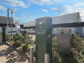 A utility box labeled 'Clever' with a street lamp nearby, set against a building with a clear sky. - 6 Person Holiday Home in Brovst (Brovst)