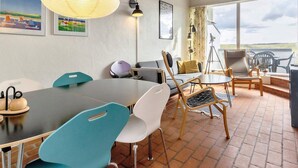 Uma sala de reuniões moderna com uma mesa grande, cadeiras, um sofá e obras de arte nas paredes.