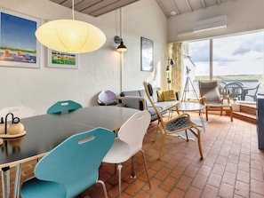 A modern meeting room with a large table, chairs, a sofa, and artwork on the walls. - 6 Person Holiday Home in Brovst (Brovst)
