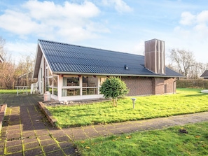 A modern house with a sloped roof, a brick exterior, and a covered porch.