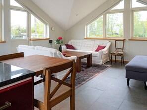 A modern interior with a dining area, a sofa set, and a windowed room. - Holiday Home in Onsala (Gottskar)