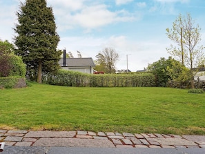 A well-maintained grassy yard with a stone pathway leading to a house with a chimney. - Holiday Home in Onsala (Gottskar)