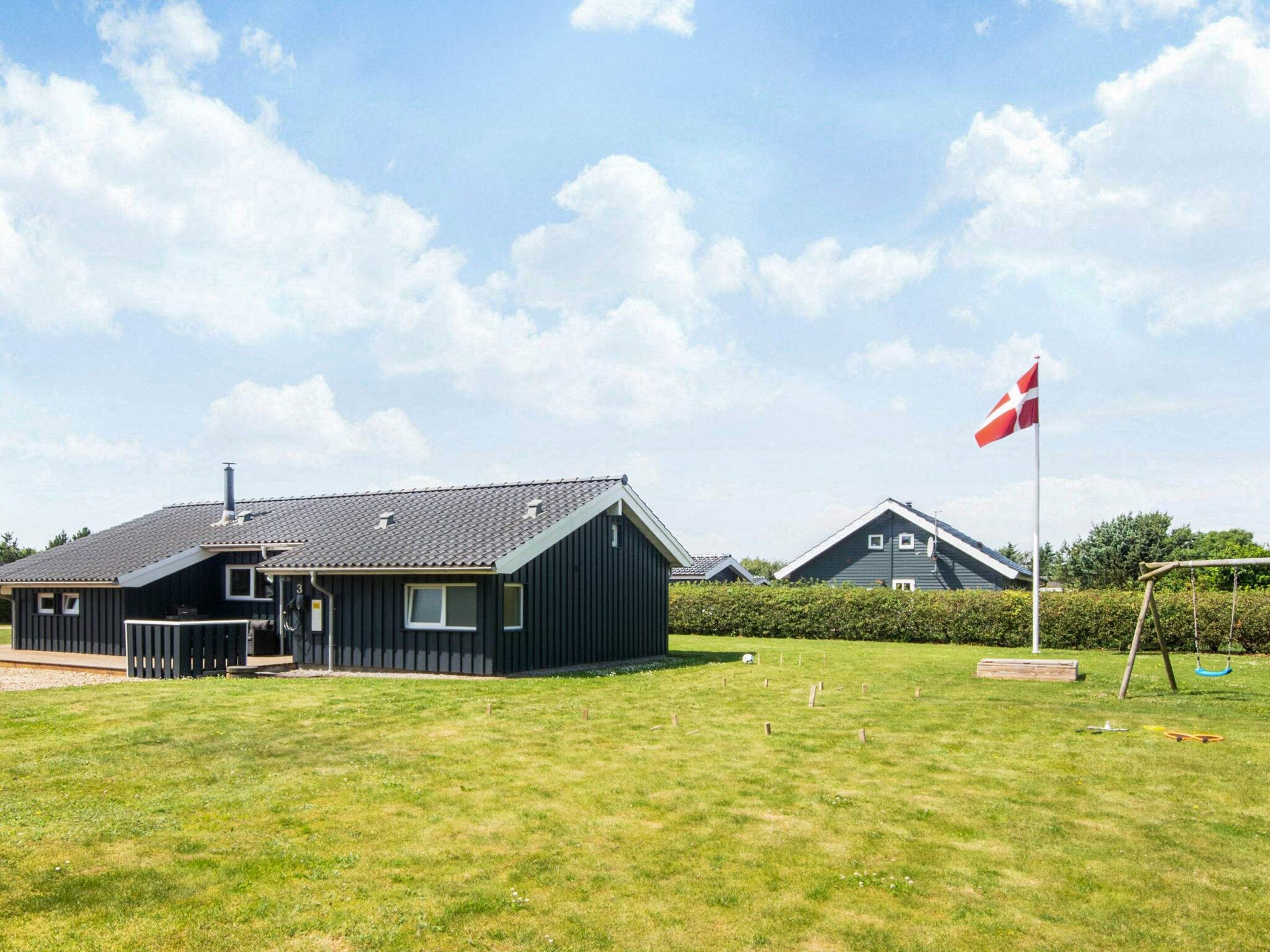 Zona residencial con casas, una bandera y un campo cubierto de césped.