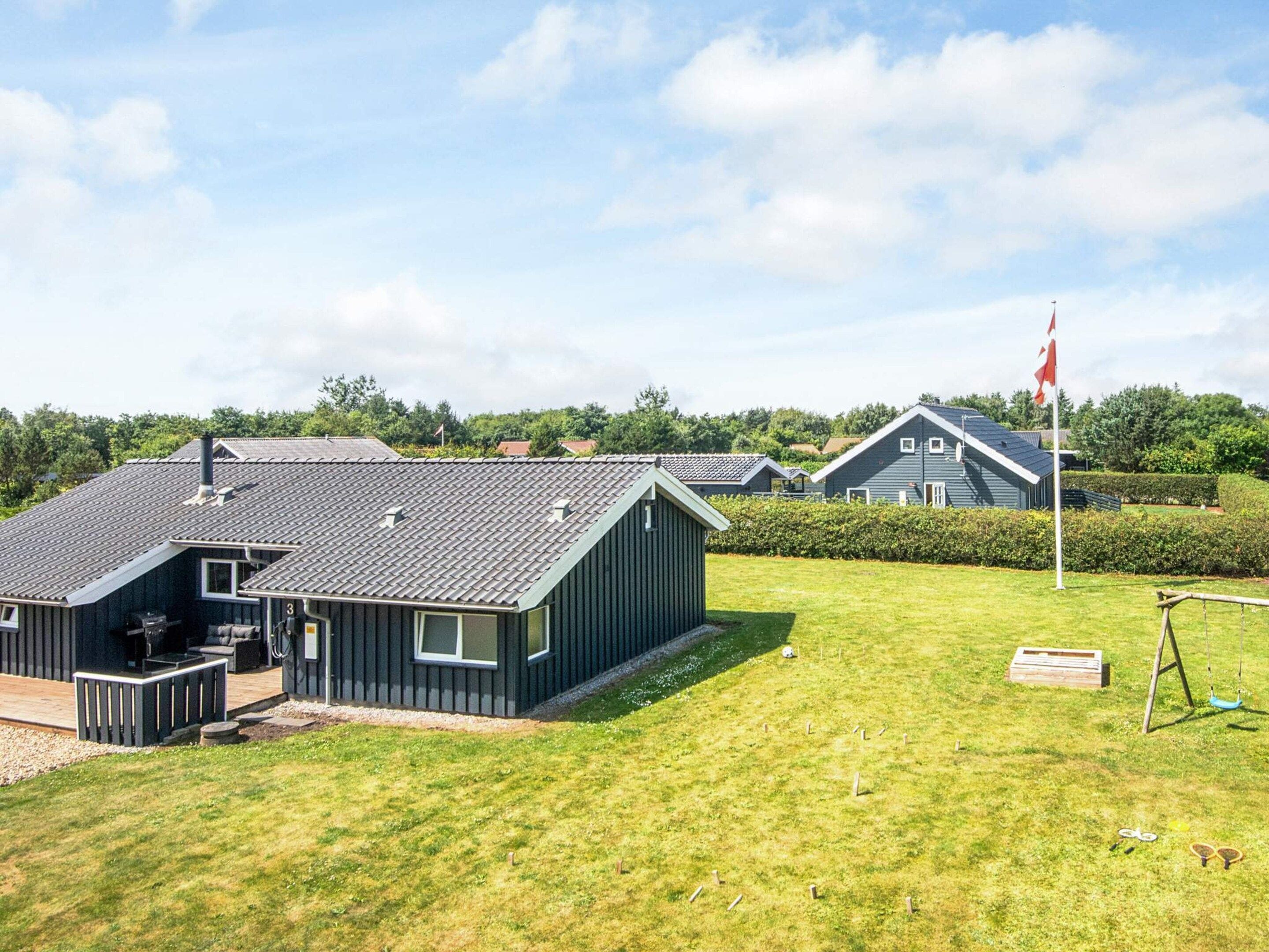 A residential area with multiple houses, a flag, and a grassy field.